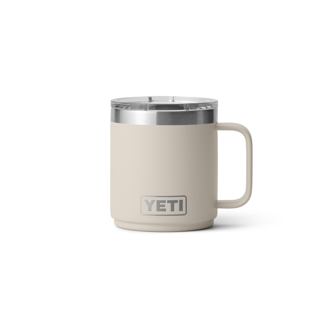 Beiger YETI Isolierbecher mit Henkel - Windsport Fehmarn Ein beiger YETI Isolierbecher aus Edelstahl mit Deckel und Henkel auf weißem Hintergrund.