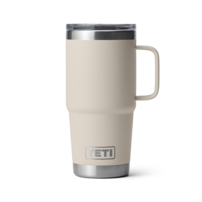 Ein beiger, isolierter YETI-Trinkbecher mit Henkel und transparentem Deckel vor weißem Hintergrund.
