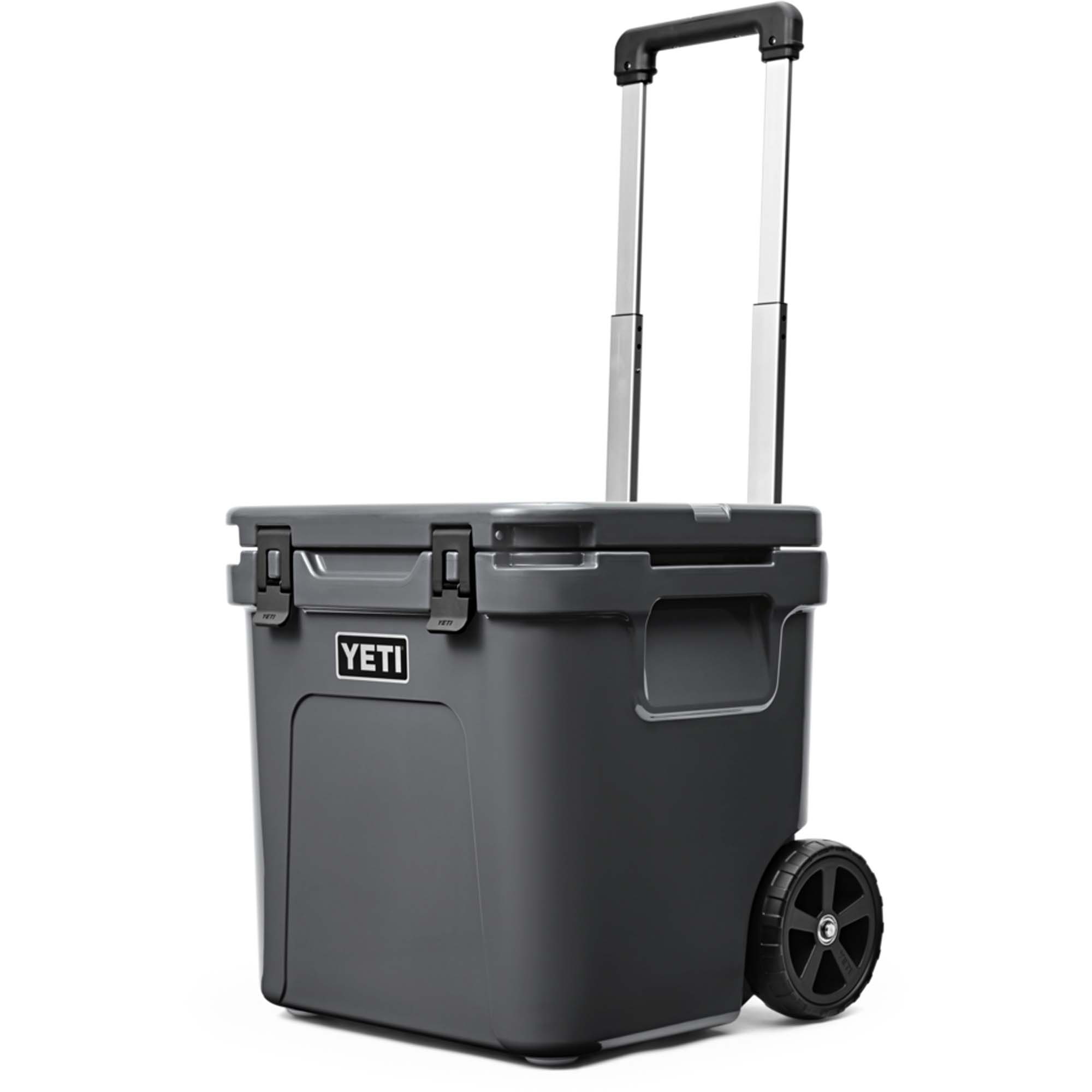 Yeti Roadie Kühlbox mit Rollen - Windsport Fehmarn Dunkelgraue Yeti Kühlbox auf Rollen mit ausziehbarem Teleskopgriff vor weißem Hintergrund.
