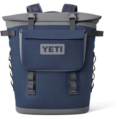 Dunkelblauer YETI Hopper Rucksack mit grauen Akzenten und aufgesetzter Fronttasche vor weißem Hintergrund.