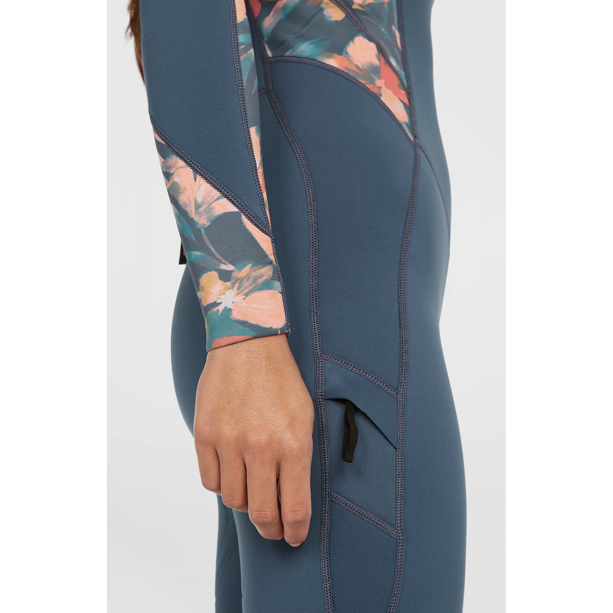 O'Neill Bahia Neoprenanzug Damen - Windsport Fehmarn Detailansicht eines blauen O'Neill Bahia Damen-Neoprenanzugs mit floralem Muster an den Ärmeln und Taschenelement.