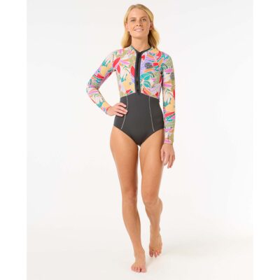 Frau in einem langärmeligen Rip Curl Surf-Badeanzug mit buntem Blattmuster auf weißem Hintergrund.