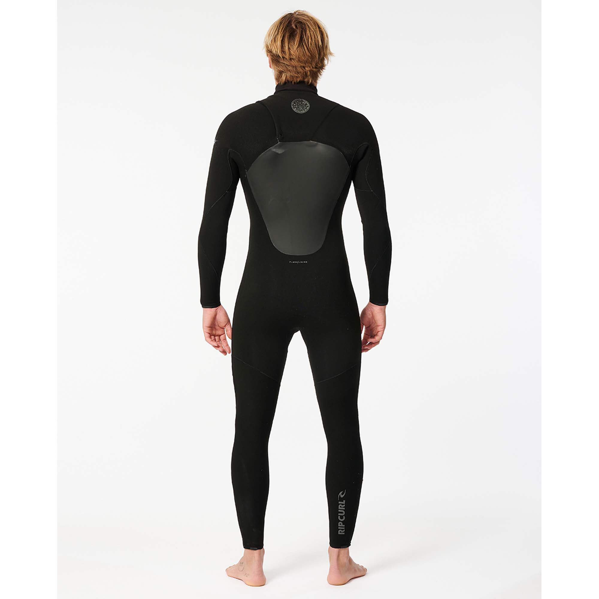 Rip Curl Flashbomb Neoprenanzug - Windsport Fehmarn Rückansicht eines blonden Mannes in einem schwarzen Rip Curl Flashbomb Neoprenanzug vor weißem Hintergrund.