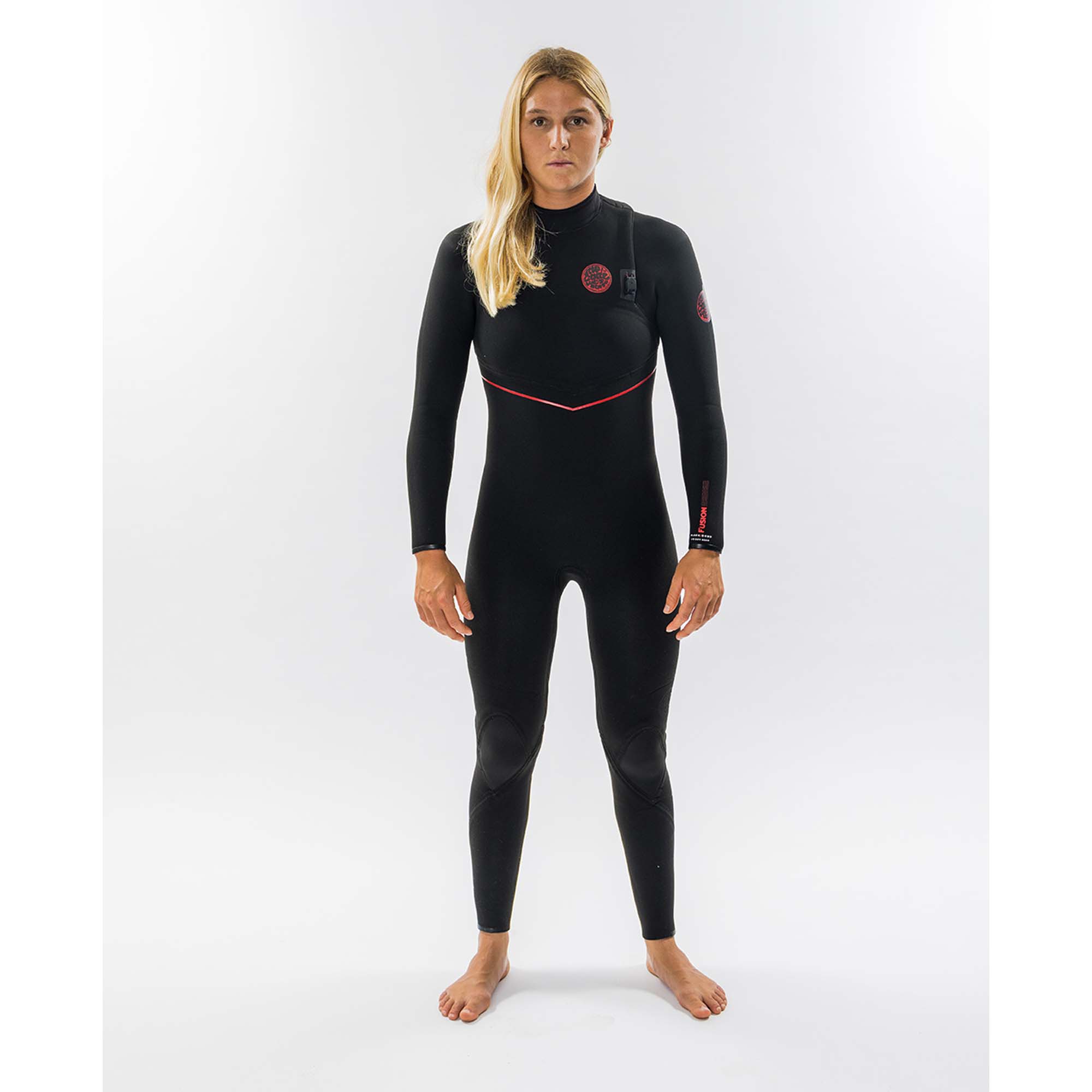 Rip Curl Damen-Neoprenanzug Fusion - Windsport Fehmarn Eine Frau trägt einen schwarzen Rip Curl Fusion Neoprenanzug mit roten Details vor weißem Hintergrund.
