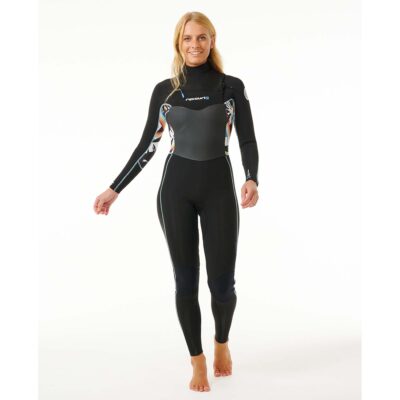 Eine lächelnde Frau trägt einen schwarzen Rip Curl Neoprenanzug mit bunten grafischen Details an den Ärmeln vor weißem Grund.