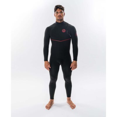 Ein Surfer steht in einem schwarzen Rip Curl Neoprenanzug mit roten Details vor weißem Hintergrund.