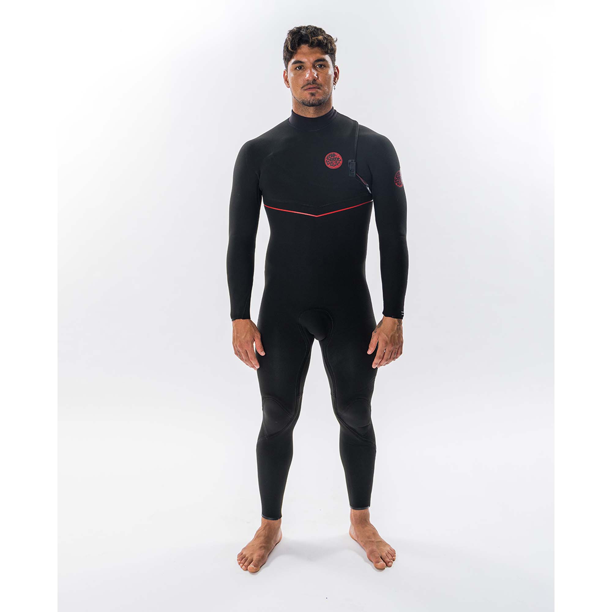 Rip Curl Herren Neoprenanzug - Windsport Fehmarn Ein Surfer steht in einem schwarzen Rip Curl Neoprenanzug mit roten Details vor weißem Hintergrund.