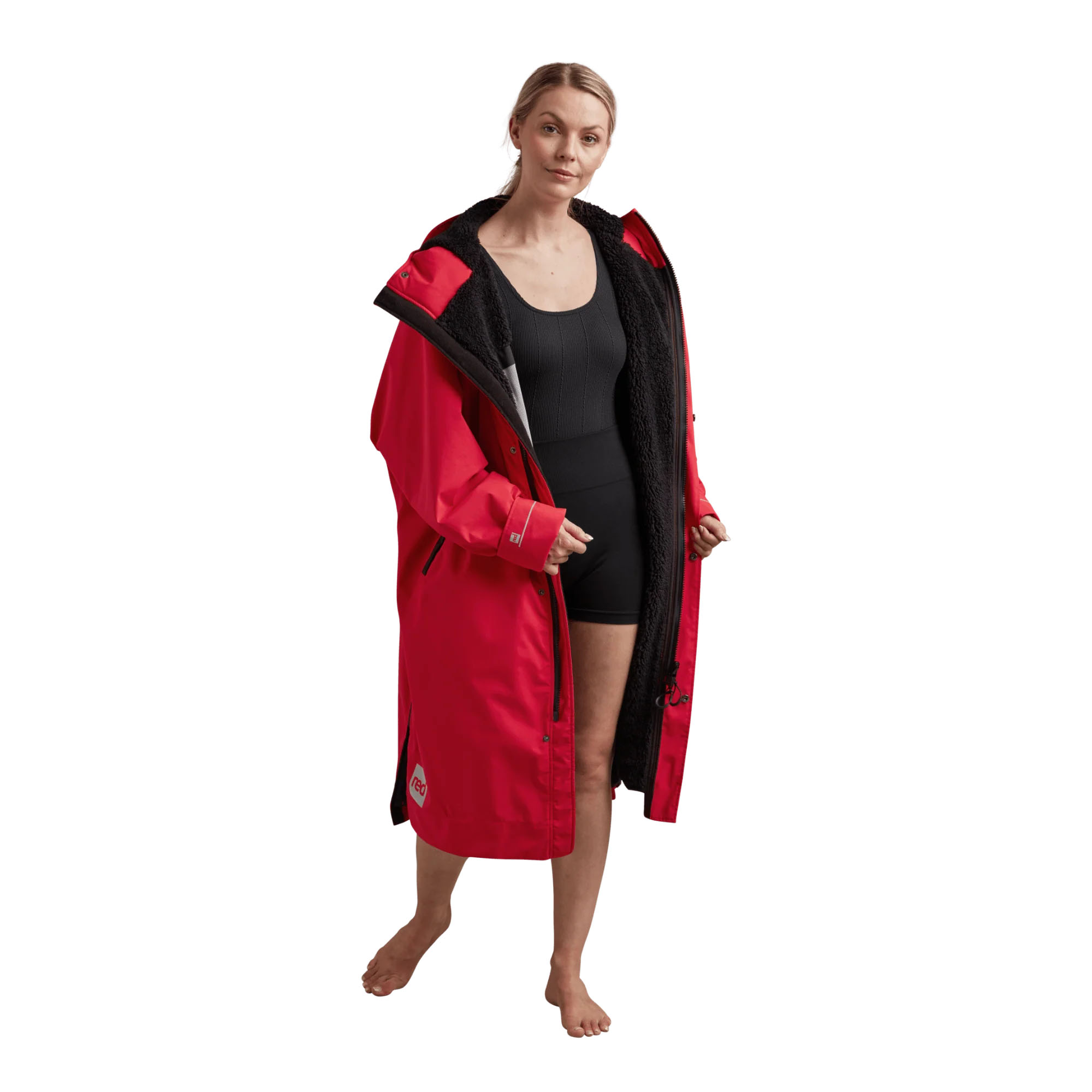 Red Original Pro Change Robe - Windsport Fehmarn Frau trägt einen roten, gefütterten Red Original Pro Change Robe über schwarzer Sportkleidung auf weißem Hintergrund.